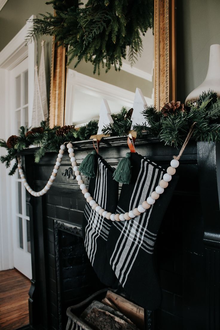 a fireplace decorated for christmas with stockings and garland