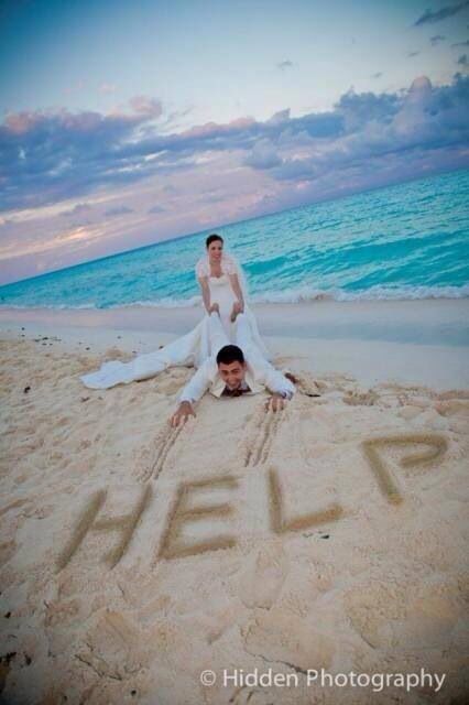 a man and woman sitting in the sand on top of a beach next to the ocean