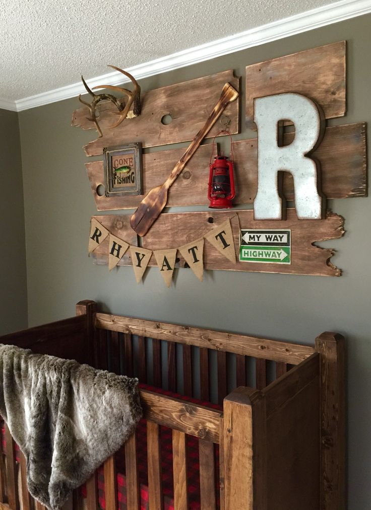 a baby's room decorated in rustic style with deer head and letters on the wall