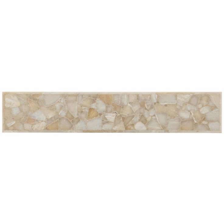 a white and beige tile border with small rocks on the bottom, in an irregular pattern