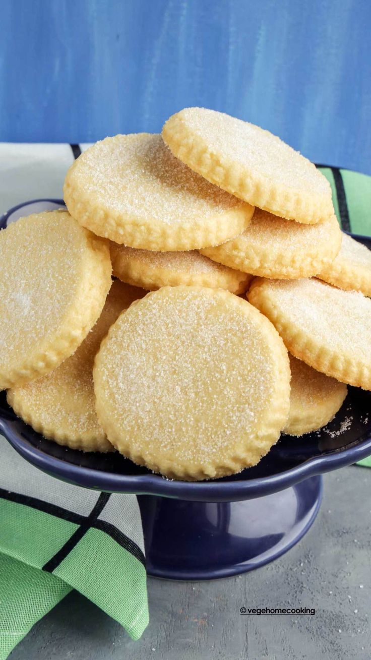 a blue bowl filled with sugar cookies on top of a table