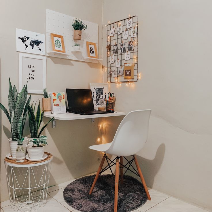 a white chair sitting next to a laptop computer on top of a desk in a room