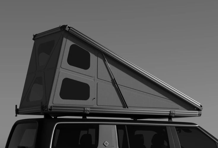 a black and white photo of a van with a roof tent on it's top