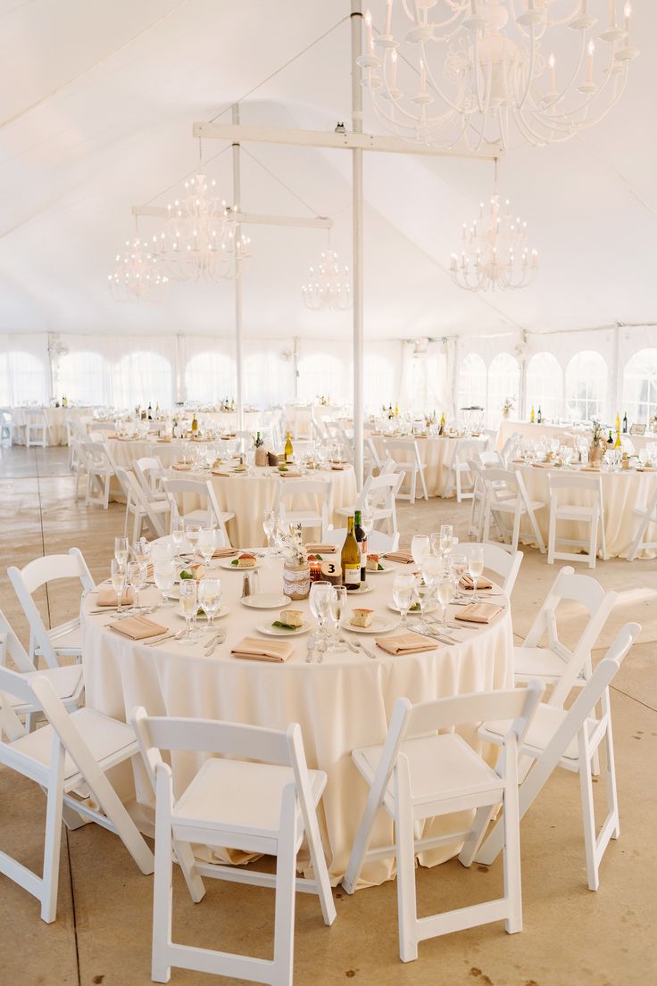 a white tent with tables and chairs set up for a formal dinner or banquet event