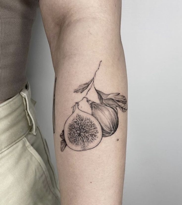 a woman with a tattoo on her arm holding up a piece of fruit and onion