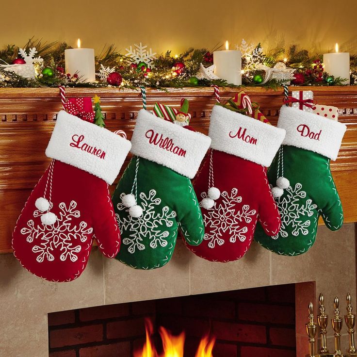 three christmas stockings hanging from a mantel over a fire place with candles and decorations