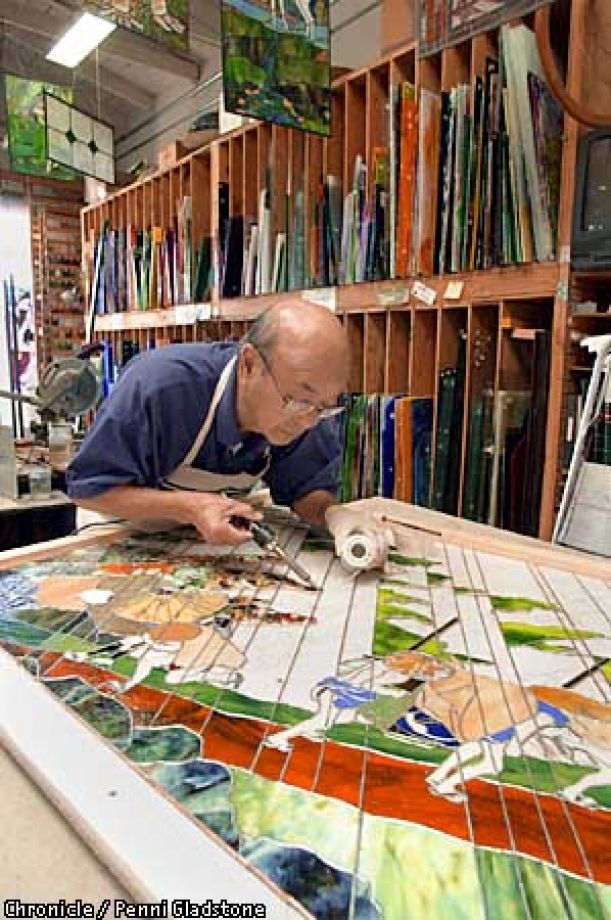 a man working on a mosaic in a shop