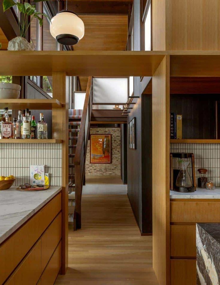 an open kitchen and dining room area with wooden cabinets, counter tops, and shelves