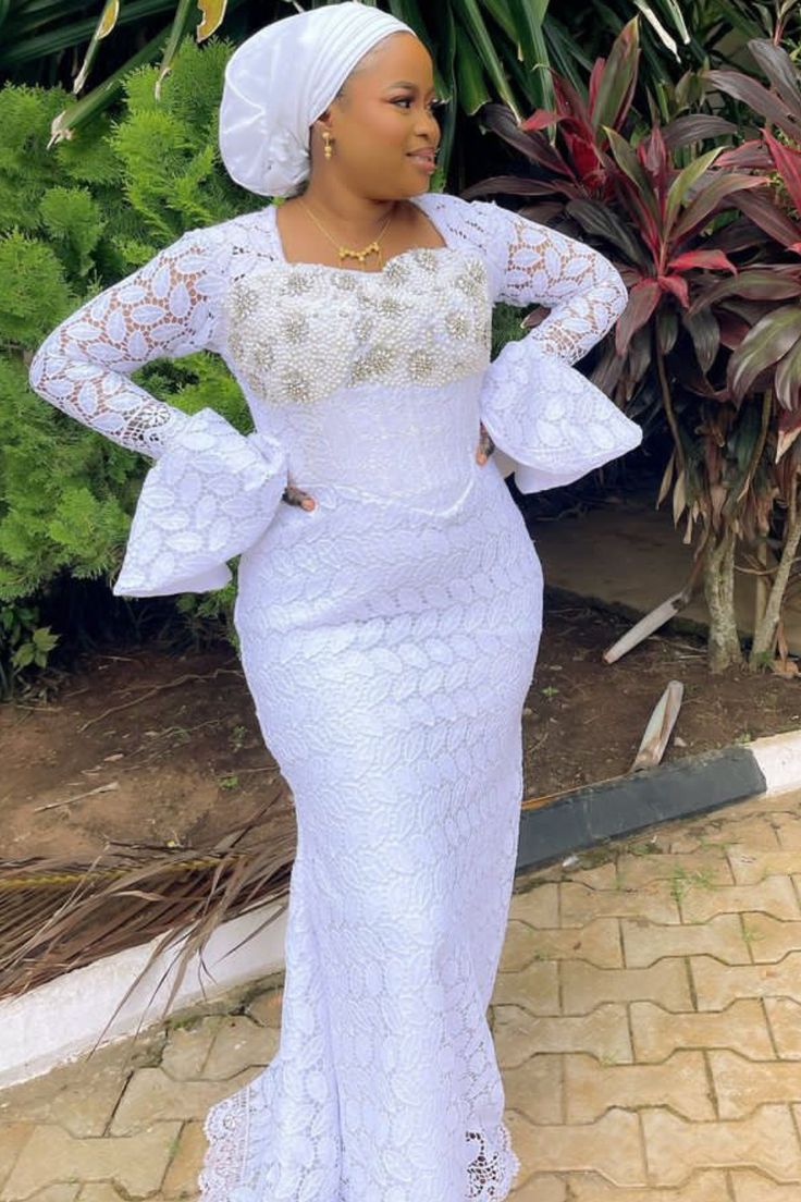 A lady wearing a white lace gown White Lace Gown Styles For Ladies, White Lace Styles For Ladies, Lace Gown Styles 2023, White Lace Styles In Nigeria, Dry Lace Styles, White Lace Gown Styles Nigerian, Dry Lace Gown Styles Nigerian, Latest Lace Gown Styles, White Lace Styles