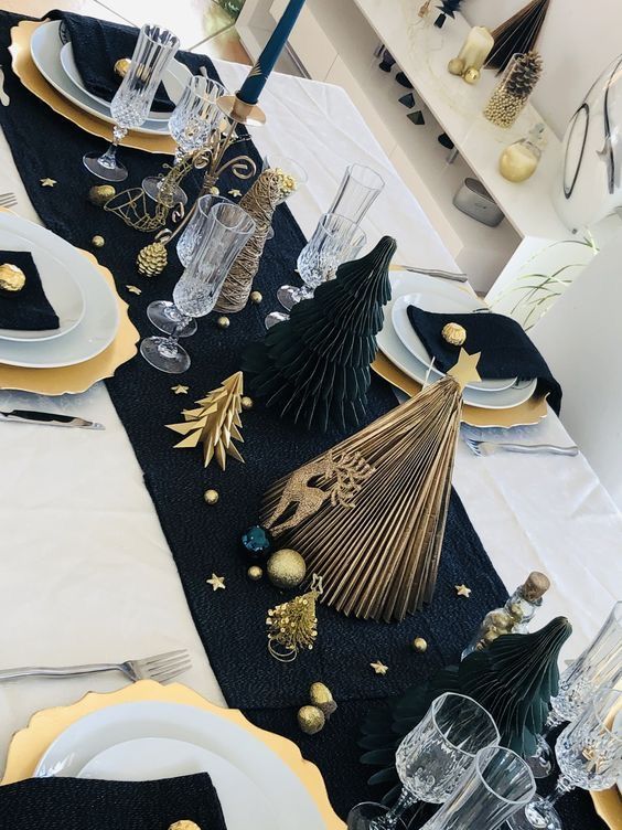 the table is set with black and gold decorations