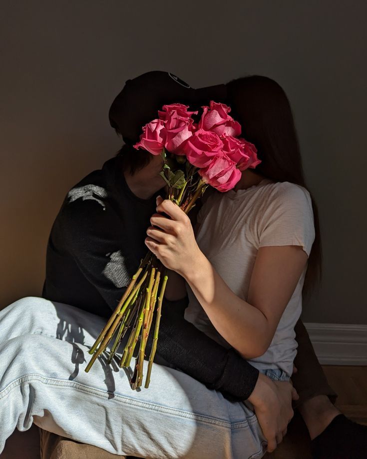 a woman sitting on the ground holding flowers