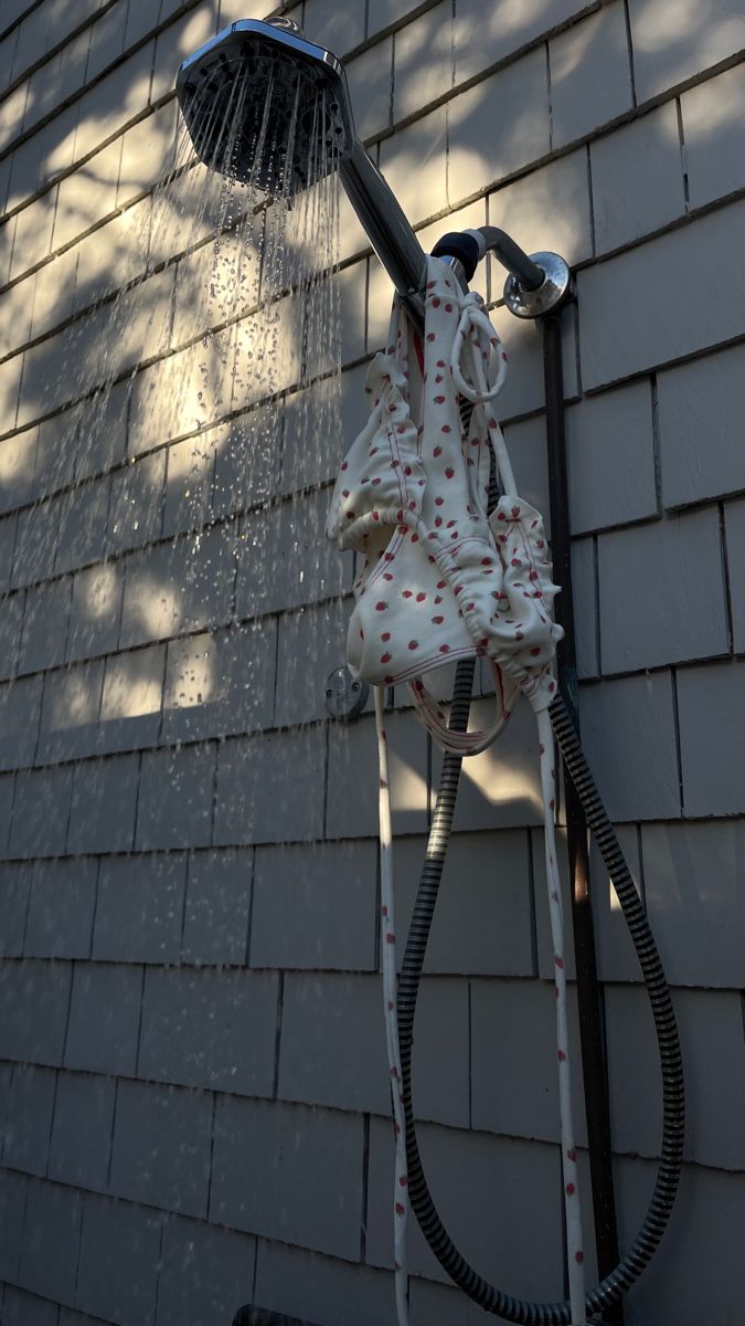 a shower head and hose attached to the side of a house