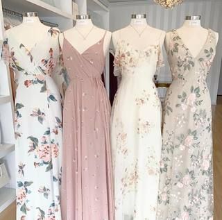 four bridesmaid dresses on display in a store