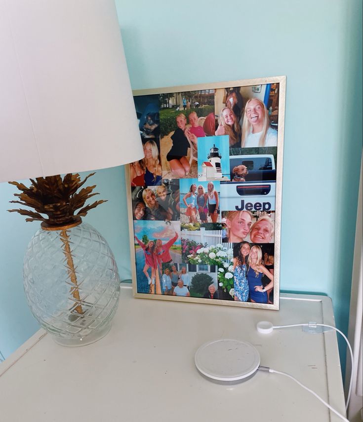 a pineapple sits next to a lamp on a white table in front of a blue wall