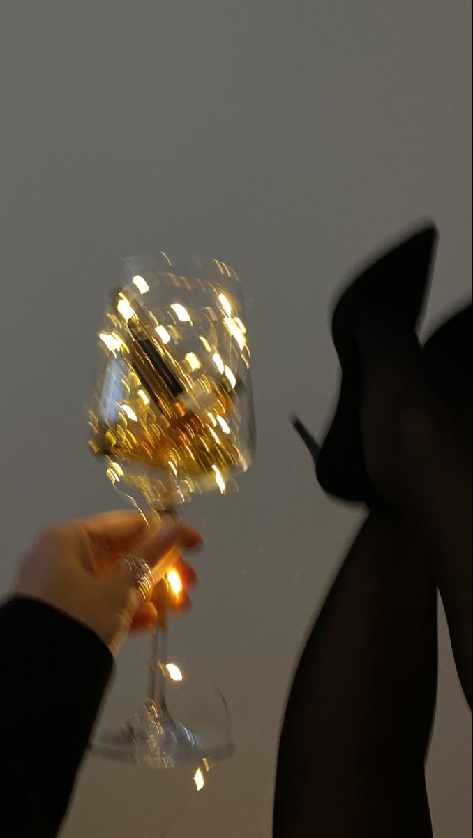 a person holding a wine glass in their hand