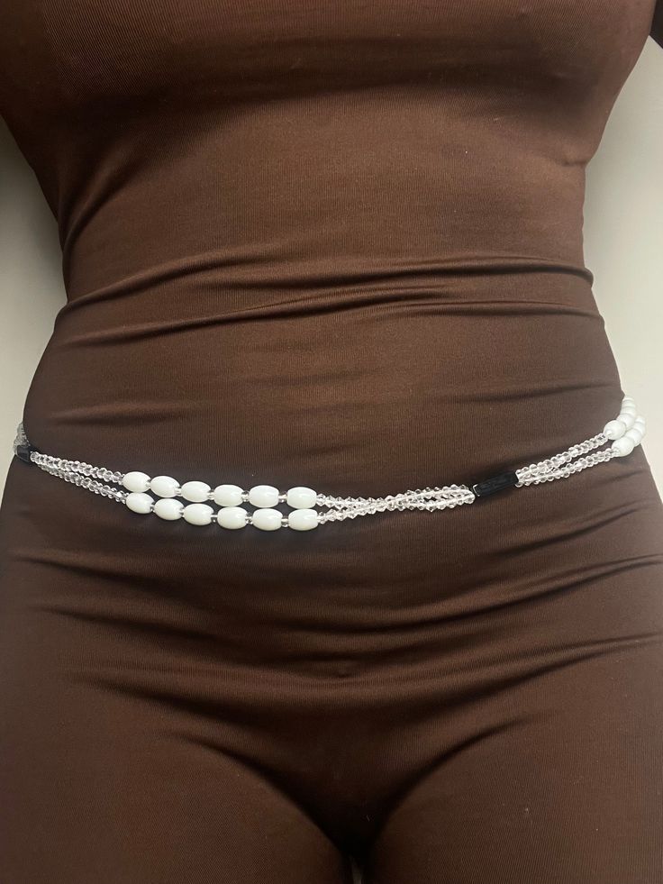 Double Strand Waist Bead "Bédiala" features: 🔍 Clarity and Purity: Bédiala begins with clear glass beads, representing clarity and purity. In Ivorian culture, clearness often symbolizes insight and the ability to see beyond surface appearances. ⚫ Black Accents: Interspersed along the strands are black crystal glass bead accents, infusing an element of mystery and strength. Black is associated with depth, resilience, and the unknown, echoing the strength found in the mysteries of life. 🔄 Custom Elegant White Beaded Waist Beads, Adjustable White Beaded Chain Waist Beads, Adjustable White Beaded Waist Beads, Adjustable White Waist Beads, White Oval Beaded Chain Jewelry, Spiritual Beaded Clear Jewelry, Spiritual Clear Beaded Jewelry, Adjustable White Waist Beads As Gift, Adjustable White Waist Beads For Gift