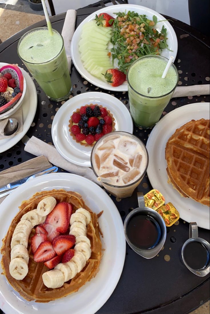 a table topped with waffles covered in fruit