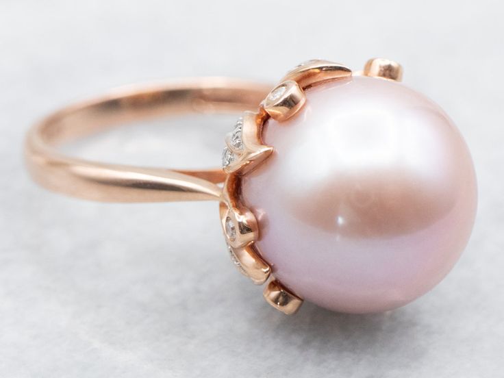 This stunning ring is filled with shades of pink and rose! This is a blushing pink pearl, shining bright and filled with luster. Surrounding the pearl is a botanical mounting set with high-quality diamonds, bringing glitter and light into this dreamy cocktail piece.Metal: 14K Rose Gold Gem: Pink Pearl Gem Measurements: 13.6 mm, RoundAccents: 48 Diamonds totaling .20 Carats Ring Size: 7Marks: "14K IPS" Stamped on the inside band Pink Pearl Jewelry, Pink Pearl Ring, Shiny Rings, Pink Pearls, Diamond Cocktail Ring, Diamond Cocktail Rings, Shades Of Pink, The Pearl, Pink Pearl