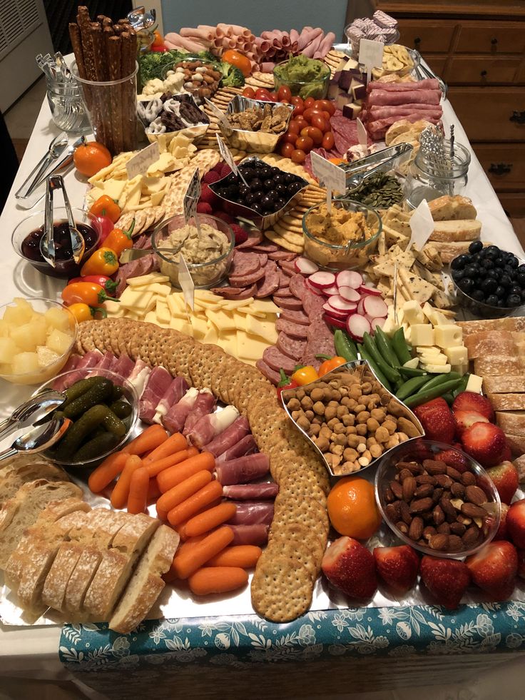 a table full of different types of food on it's sides, including meats, cheeses and fruit