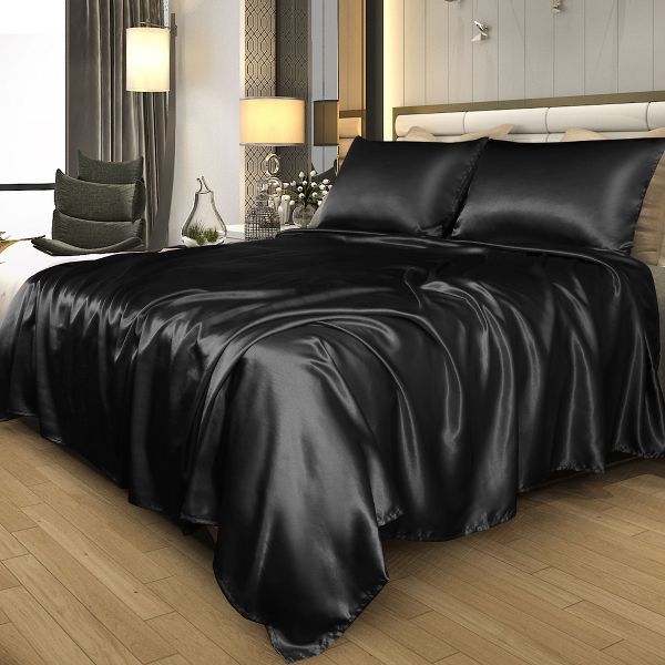 a bed with black sheets and pillows in a room