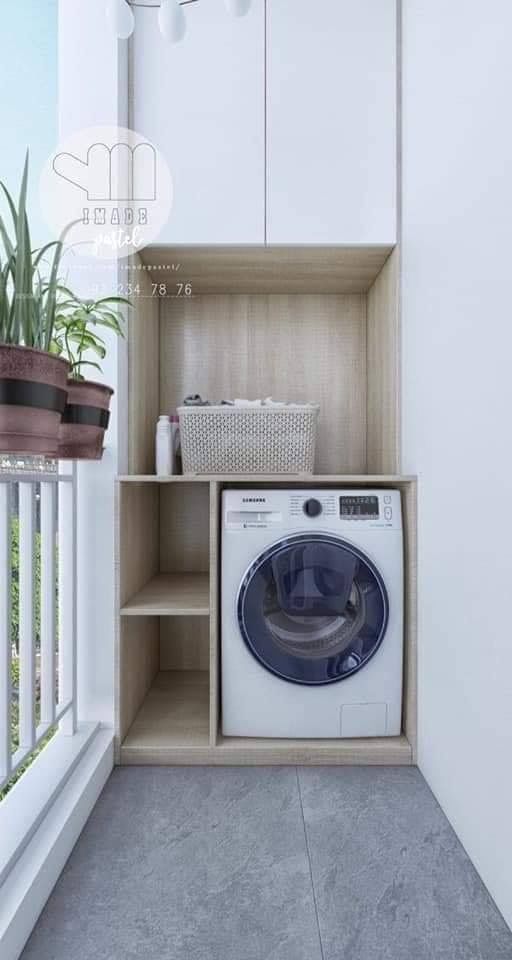 a washer and dryer sitting in a small room next to a balcony with potted plants