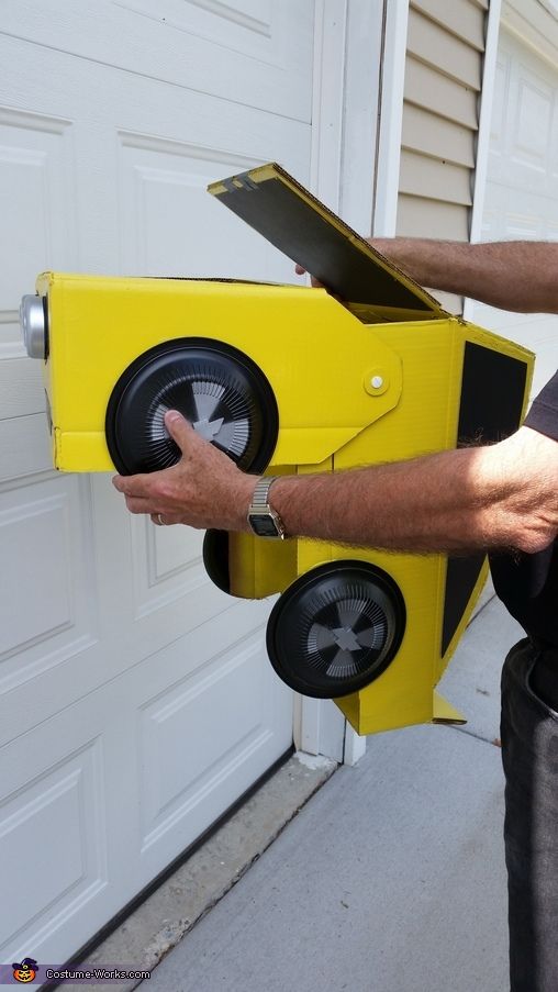 a man is holding a yellow box shaped like a car