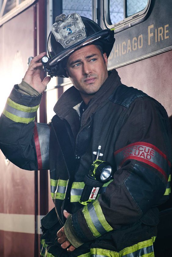 a man in a fireman's uniform standing next to a train