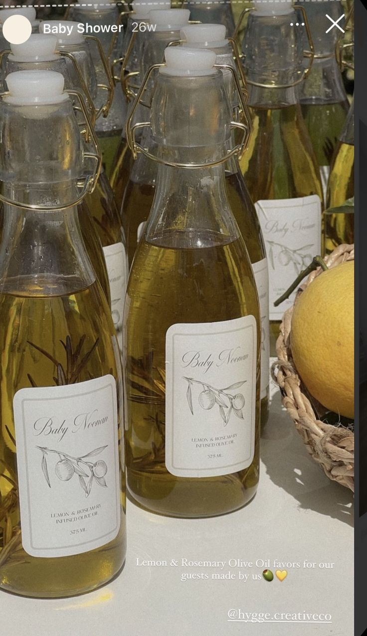 several bottles of olive oil sitting on a table with lemons and other items in the background