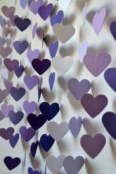 purple and white hearts hanging from the side of a wall