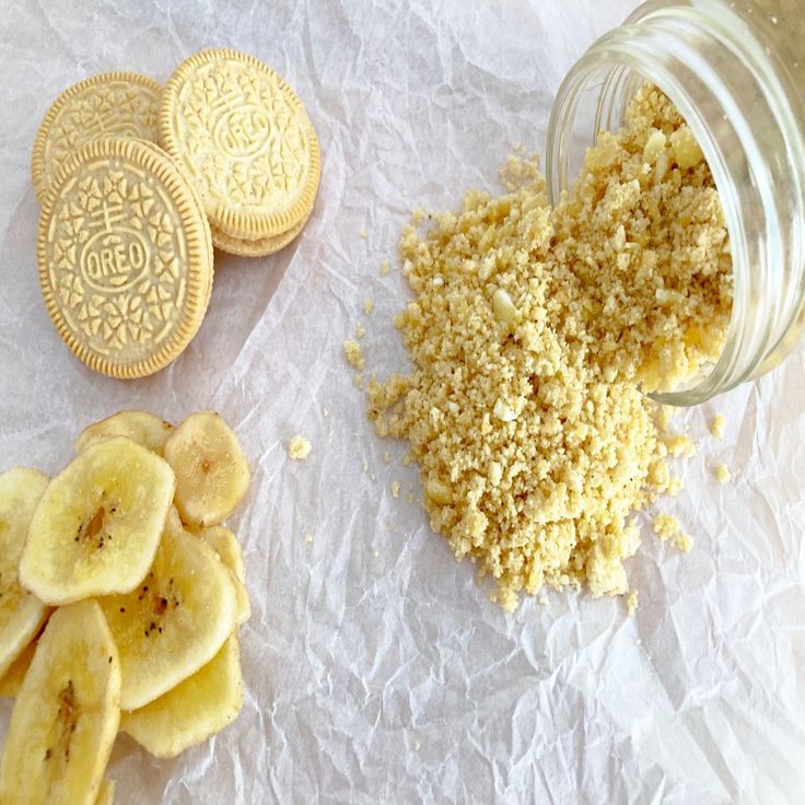 some cookies and bananas are next to a jar of oatmeal crumbs