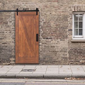 a fire hydrant sitting in front of a brick building next to a wooden door