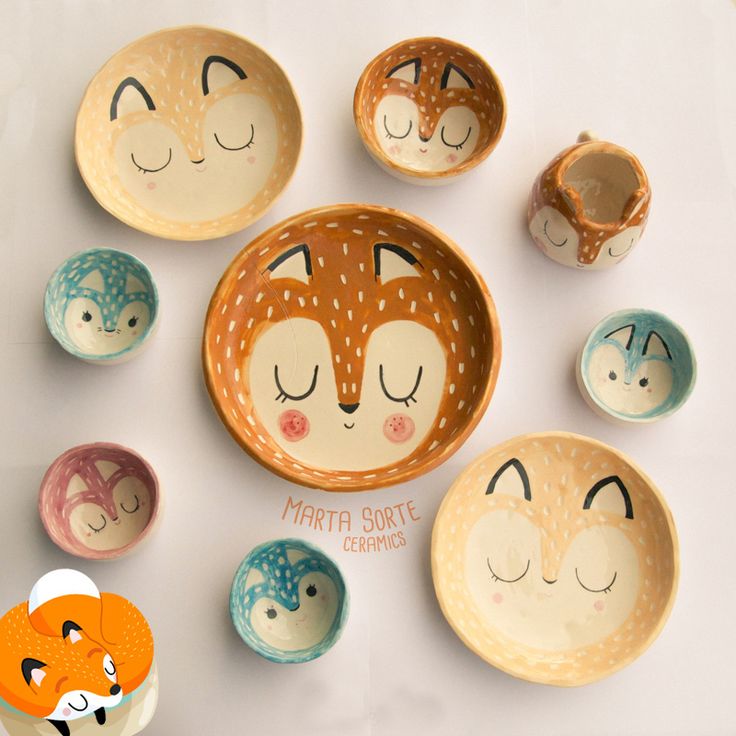 small bowls with faces painted on them are arranged in the shape of foxes and cats