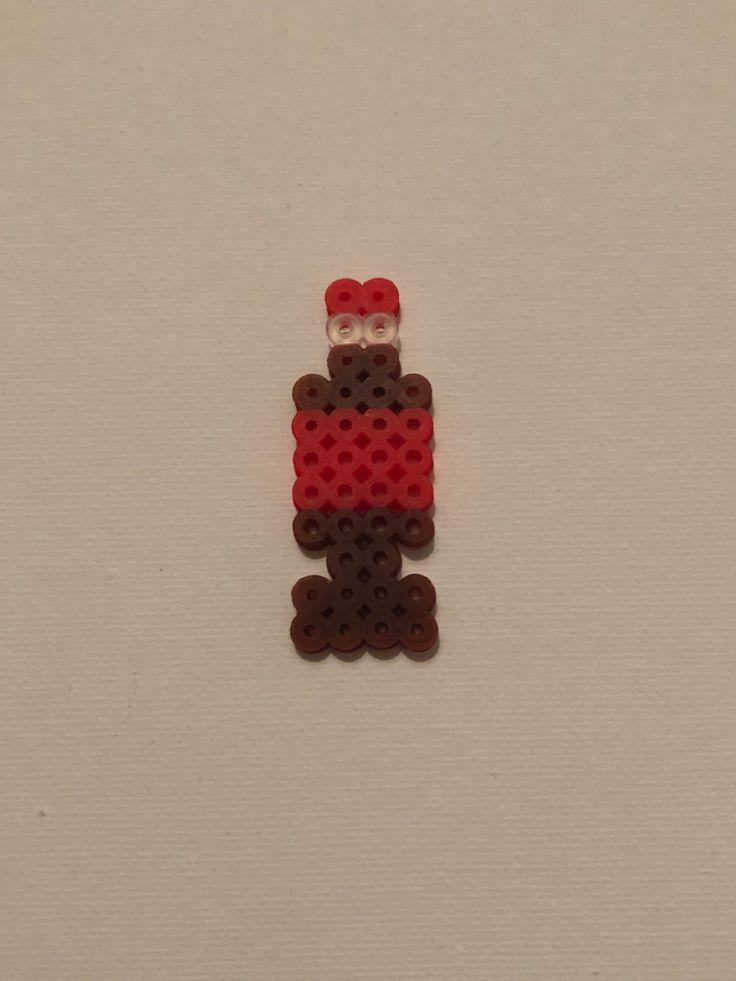 a red and brown beaded object sitting on top of a white surface