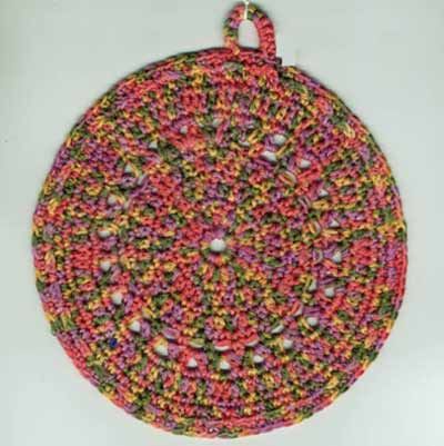 a crocheted round ornament hanging on a white wall in the shape of a circle