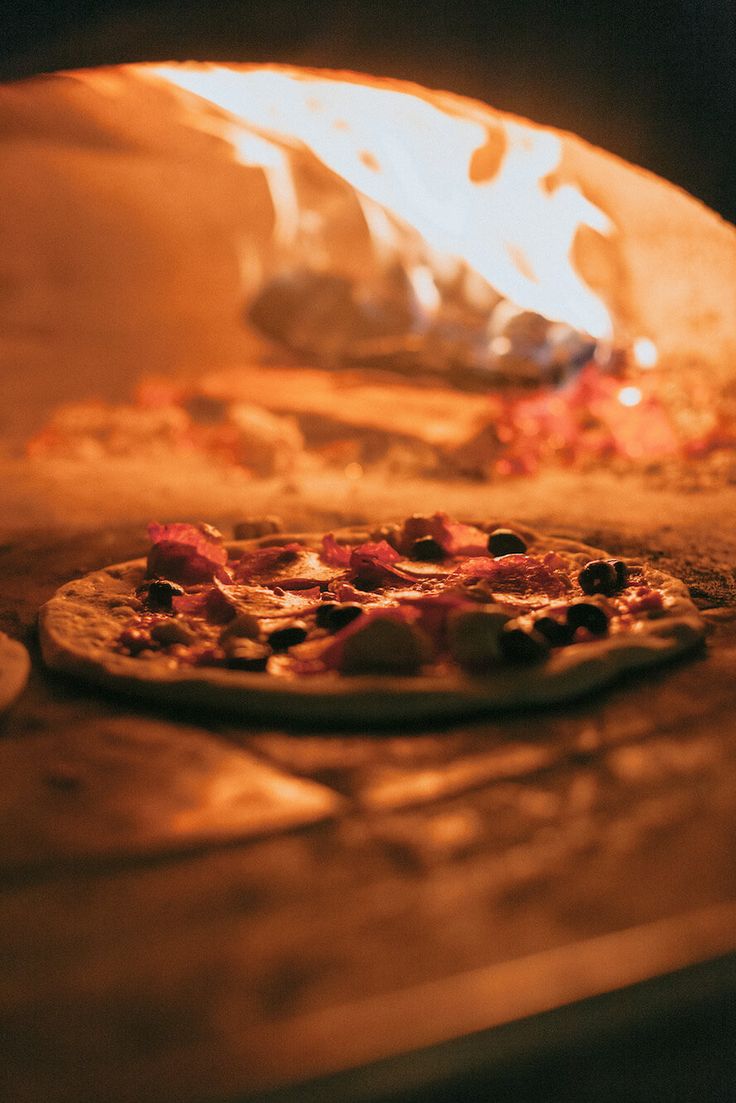 a pizza is cooking in an oven with flames