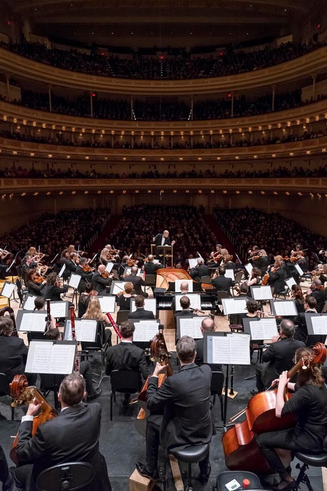 an orchestra performing in front of a large audience