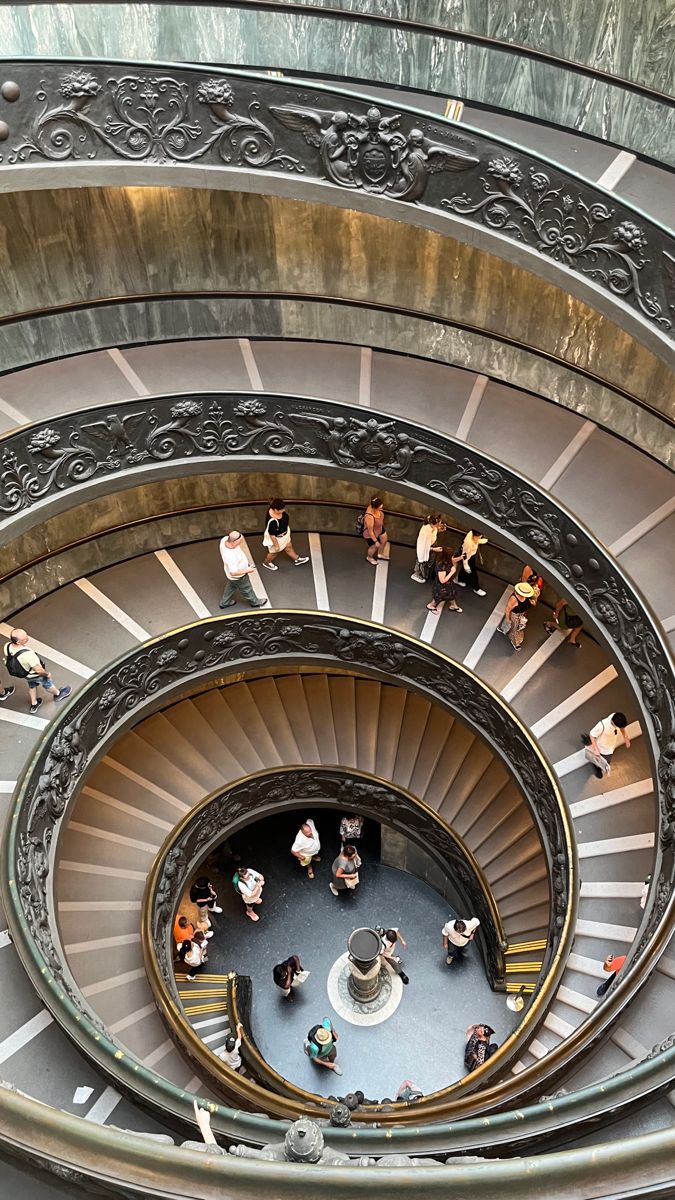 several people are standing in the middle of a spiral staircase