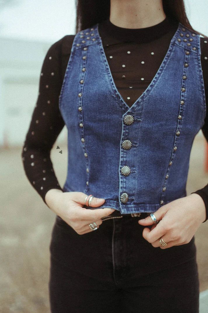 this vest thoughhh especially paired with a good mesh top.it's a dreamy combo.this vest would pair with anything really.you could pair it with a tee, mesh, dress,long sleeve top, or even just wear it by itself.it's truly the PERFECT layering piece.Don't be afraid of them layerz.we used a stretchy denim for this vest.it has JUST THE RIGHT AMOUNT of stretch.not too much.can we just take one last moment to appreciatethe BUTTONS and CONCHO STUD detailing.we're a sucker for some details.denim vest.co Denim Vest Top Outfit, Denim Vest Concert Outfit, Trendy Denim Vest Top For Fall, Trendy Fall Denim Vest Top, Denim Blue Vest Top For Spring, Medium Wash Denim Vest Top For Fall, Denim Blue Vest Top For Fall, Fall Medium Wash Denim Vest Top, Fitted Vest For Summer Layering