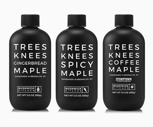 three bottles of tree's knees ciderbread maple syrup on a white background