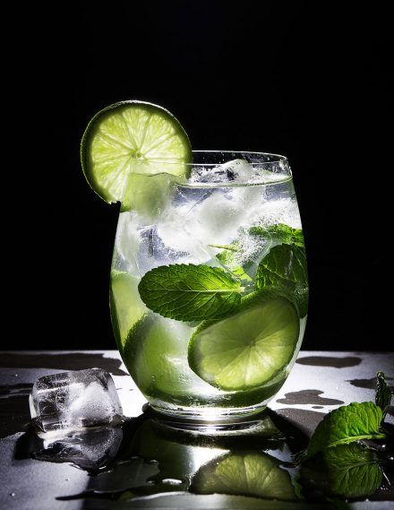 a glass filled with ice and lime slices