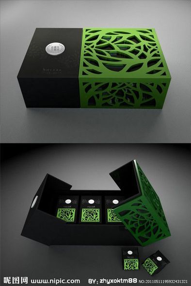 an open box with green and black designs on the inside, sitting on top of a table