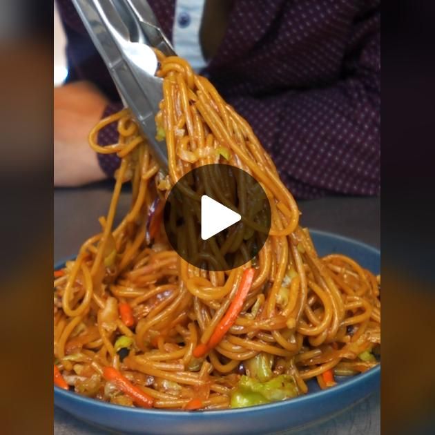 someone is using tongs to stir noodles on a plate