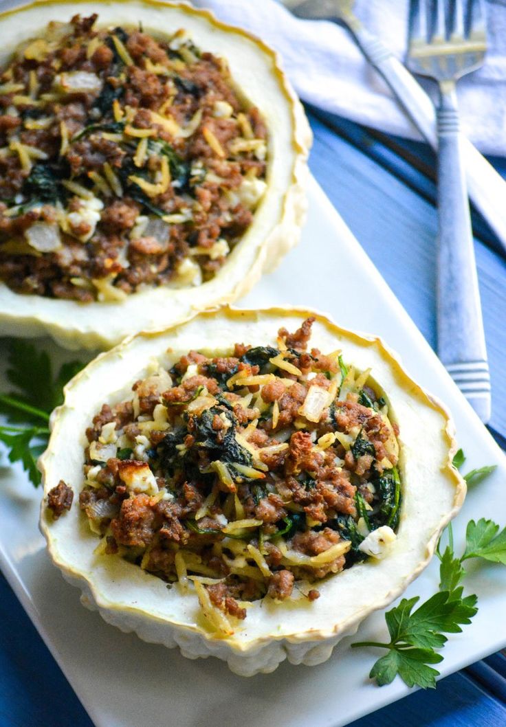 two baked delicacies on a plate with silverware