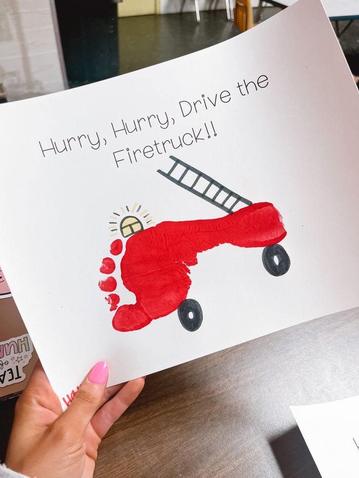 a person holding up a card that says, hurry harry drive the firetruck