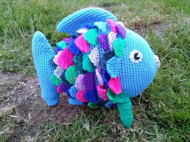 a crocheted stuffed fish sitting in the grass