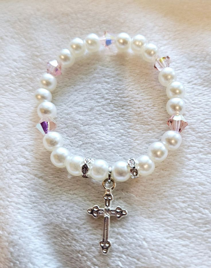 Infant/ Toddler/ Child Stretch Bracelet Sizing available as needed, Please see pictures for chart with size references.  Pearl With Silver Rhinestone  spacers, Pink Czech Glass Beads, Silver Cross. Perfect for Baptism or First Communion.  Gently hand crafted for You! Gently Handcrafted for You! Sizes: 4 inches - 0-3 months 4.5 inches - 3-9 months  5 inches - 9-24 months 5.5 inches - 2-4 years  6 inches- 4- 8 years *Please note: These are only estimated sizes. Specific measurements will ensure a White Adjustable Hypoallergenic Rosary Bracelet, Hypoallergenic White Jewelry For Baptism, Adjustable White Bracelet For Baptism, Personalized White Beaded Bracelets For Baptism, Adjustable White Bracelet For Confirmation, White Adjustable Bracelet For Confirmation, Adjustable Rosary Bracelet With Round Beads For Baptism, Adjustable White Rosary Bracelet For Confirmation, Handmade White Bracelet For Baptism