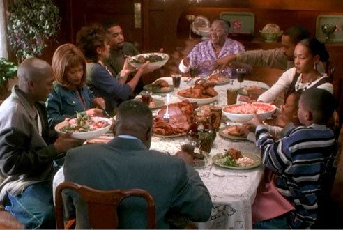 a group of people sitting around a table with plates of food in front of them