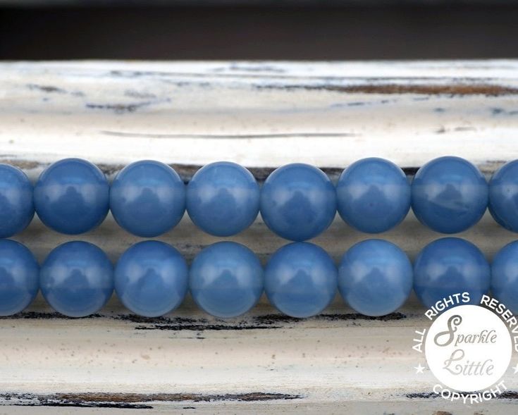 blue beads are lined up on an old window sill