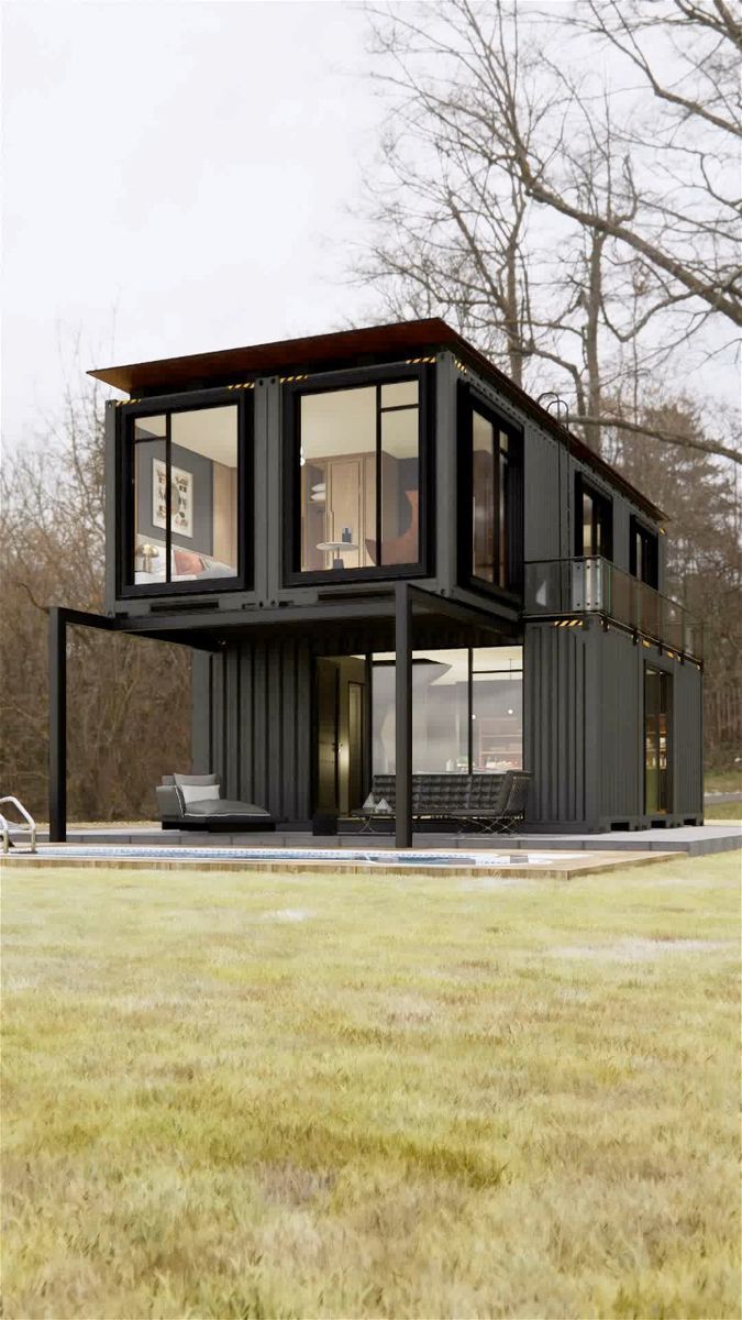 a house made out of shipping containers sitting on top of a grass covered field