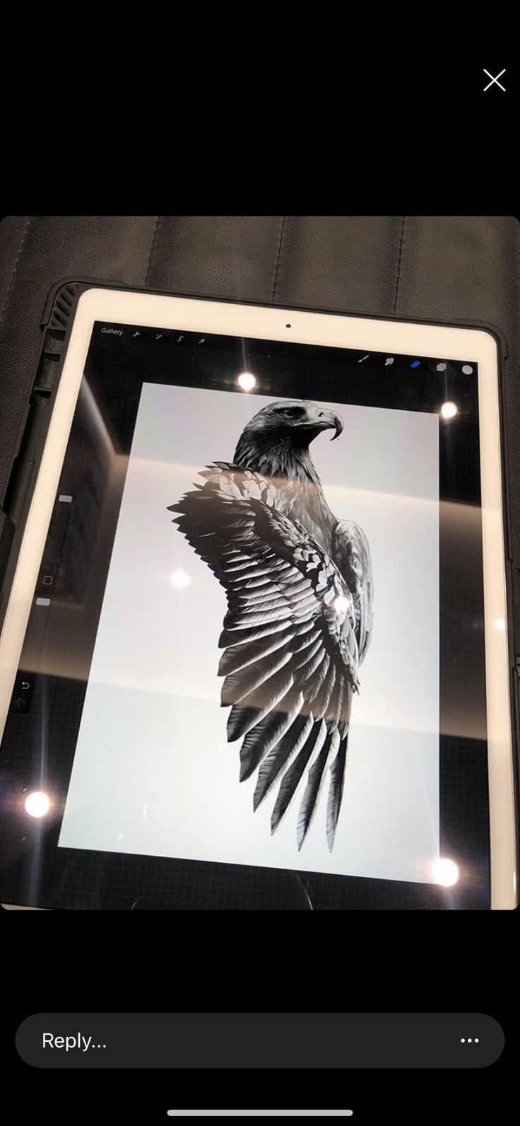 an image of a bird on the screen of a tablet computer with its wings spread out